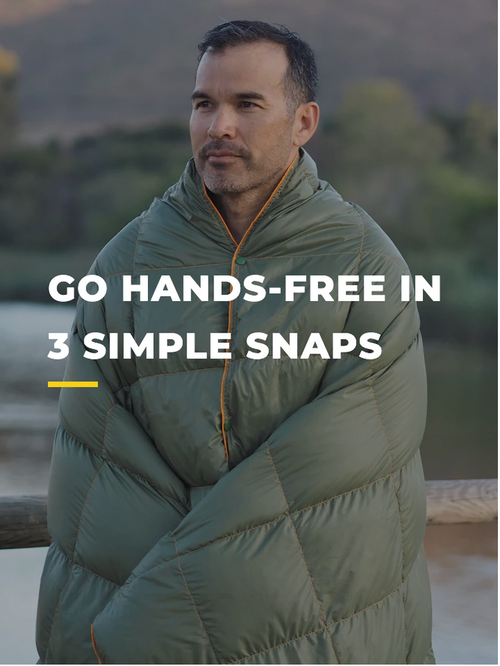 A man standing outdoors wrapped in a green quilted blanket, fastened so his hands are free. Text on the image reads, Go hands-free in 3 simple snaps.
