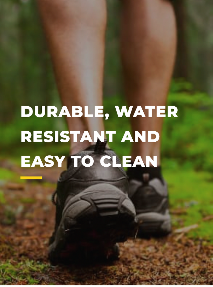 Close-up of a person’s feet wearing black athletic shoes walking on a green forest trail. Text on image reads: “Durable, water resistant and easy to clean.”.