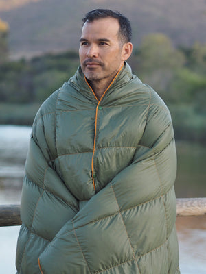Get Out Gear down camping blanket, olive, worn as a poncho.