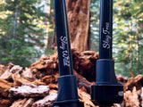 Close-up of Get Out Gear Goat Stix trekking poles with ‘Stay Wild’ and ‘Stay Free’ engraved on the black carbon fiber shafts, set against a forest background with a fallen tree.
